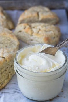 a jar of cream sitting next to some bread