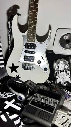 an electric guitar sitting on top of a table next to other musical instruments and accessories