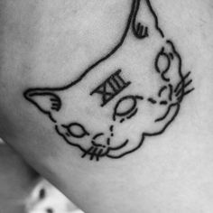 a black and white photo of a cat tattoo