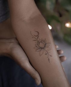 a woman's arm with a flower tattoo on the left side of her arm