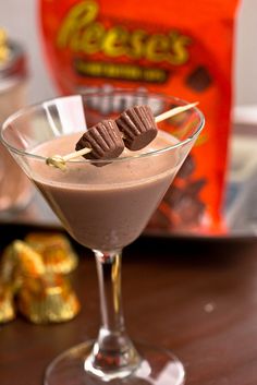 a chocolate drink in a martini glass with candy on the stick sticking out of it