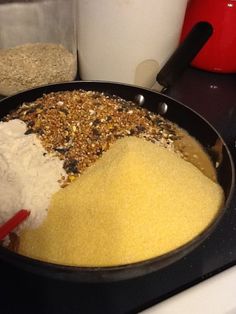 a pan filled with food sitting on top of a stove next to a red pot