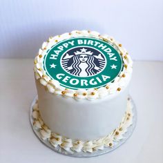 a starbucks cake with white frosting and gold sprinkles on the top