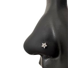 a close up view of a nose with an earring in the shape of a flower