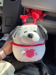 a stuffed animal in the back seat of a car with a heart on its head