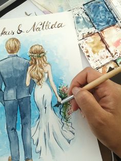 a drawing of a bride and groom with watercolors on the paper next to them