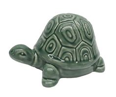 a green ceramic turtle figurine on a white background