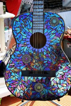 a colorful guitar sitting on top of a stand