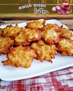 fried onion fritters on a white plate sitting on a red and white checkered tablecloth