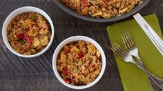 three bowls filled with rice and vegetables next to silverware on a wooden table top