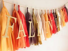 there are many tassels hanging on the wall with name spelled in gold letters