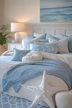 a bed with blue and white comforters, starfish pillows and blankets