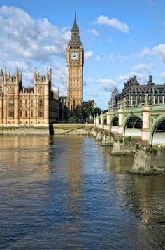 the big ben clock tower towering over the city of london from across the river thames