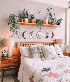 a bed with two plants on the wall above it