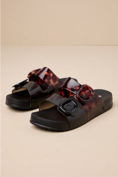 Make your casual days fashionable and extra fun with the Melissa Cozy Black and Clear Tortoise Slide Sandals! A chic combo of black and tortoise print adorns lightweight, slightly clear PVC as it shapes a classic almond-toe bed. Wide vamp straps secure with matching, adjustable buckles, all atop a 0.75"" contoured insole that makes these slide-on sandals perfect for comfortable, everyday wear! Available in whole sizes only. 0. 25" PVC lug sole. Lightly cushioned insole. Rubber sole has nonskid m Chic Jelly Sandals With Buckle Closure, Black Jelly Sandals With Buckle Closure For Vacation, Black Flat Jelly Sandals With Buckle Closure, Chic Black Sandals With Translucent Outsole, Trendy Black Jelly Sandals For Vacation, Black Adjustable Jelly Sandals, Casual Style, Adjustable Black Jelly Sandals Casual Style, Black Adjustable Jelly Sandals For Casual Wear, Casual Black Adjustable Jelly Sandals