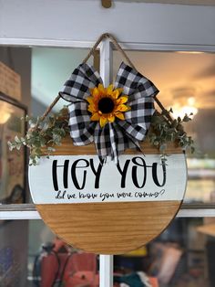 a wooden sign that says hey you and has a sunflower on it