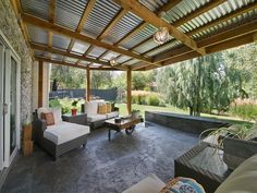 an outdoor covered patio with couches and tables