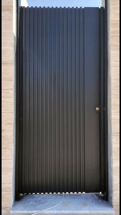 a black door is open on the side of a building