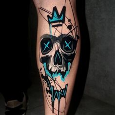 a man's leg with a skull and crown tattoo design on the calf area