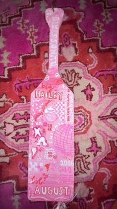 a pink luggage tag sitting on top of a carpet