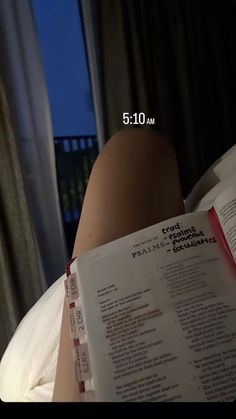 a person laying in bed reading a book