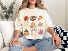 Celebrate Thanksgiving and game day with this Comfort Colors t-shirt, featuring autumnal favorites like pumpkins, pumpkin pie, and a turkey, alongside football essentials such as a helmet and goal post. Perfect for any football lover, this tee makes an excellent gift, capturing the spirit of fall with a coquette bow, leaf, and fall flower accents. COMFORT COLORS 1717 SHIRT: Unisex 100% US cotton - ethically grown and harvested Pre-Shrunk Fabric Relaxed Fit - Size up for a trendy oversized look S Football Essentials, Thanksgiving Shirt Ideas, Thanksgiving Football Shirt, Football Shirt Women, Tis The Season Football, Thanksgiving Shirts For Women, Thanksgiving Football, Thanksgiving Tee, Fall Football