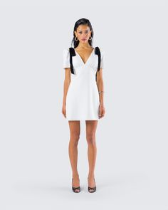 We love a little classy moment 🤍 Made from crepe fabric and featuring an invisible back zipper, velvet black bows at the shoulders, puff sleeves, and a v-neck - this white mini dress will have everyone pining over you 😌 White Mini Length V-neck Dress For Cocktail, White V-neck Puff Sleeve Formal Dress, White V-neck Party Dress With Short Sleeves, White Short Sleeve V-neck Party Dress, White Puff Sleeve Mini Dress For Evening, White V-neck Puff Sleeve Evening Dress, White V-neck Puff Sleeve Party Dress, White Puff Sleeve Mini Dress With Structured Shoulders, White Puff Sleeve Mini Dress For Night Out