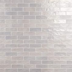 a white tile wall with grey and silver tiles