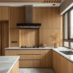 a kitchen with wooden cabinets and marble counter tops in front of a large window overlooking the city