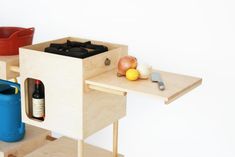 a wooden table topped with bottles and containers next to a blue container filled with food