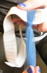 a person is tying a blue and white tie