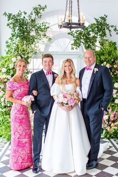 the bride and groom are posing with their parents