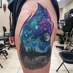 a man's thigh with a colorful tattoo on it and stars in the sky