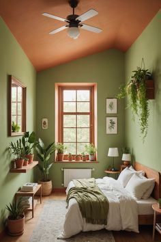 a bedroom with green walls and plants on the window sill in front of the bed