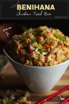 a white bowl filled with fried rice and veggies next to chopsticks