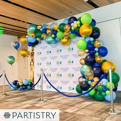 an entrance to a party with balloons on the wall and blue ropes in front of it