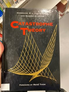 a person holding up a book about catastrophe theory