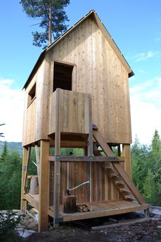 a wooden structure with stairs leading up to the upper floor and second story above it