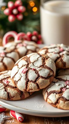 several cookies on a white plate next to a glass of milk and candy canes