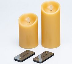 two yellow candles with remote controls next to them