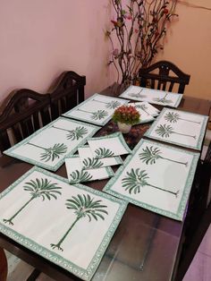 the table is set with placemats and napkins for palm trees on them