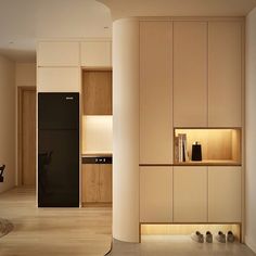 an empty room with wooden flooring and white cupboards on either side of the wall