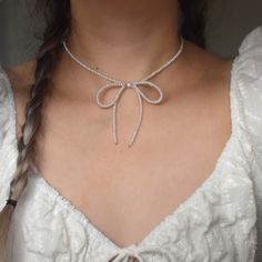 Bows, bows, bows! The cutest feminine necklace for your soft girl era. Meticulously handcrafted with care, using high luster genuine freshwater pearls and 14k gold-filled hardware. MATERIALS. Real freshwater pearls (super lustrous, AAA grade) 14k gold filled hardware Lobster clasp with 3" extender chain Bow measures approx. 2.75" wide and 3.25" long PLEASE NOTE. Freshwater pearls are unique, like you and I. Thus, each jewelry piece is one of a kind and will deviate slightly from the photos shown Bow Pearl Necklace, Pearl Crafts Ideas, Bow Necklace Diy, Sunscreen Perfume, Pearl Bow Necklace, Hardware Materials, Ribbon Knot, Simple Beaded Necklaces, Diy Choker