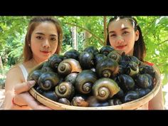 two girls holding a basket full of snails