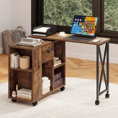 a laptop computer sitting on top of a wooden desk in front of a large window