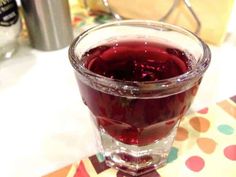 a glass filled with liquid sitting on top of a table