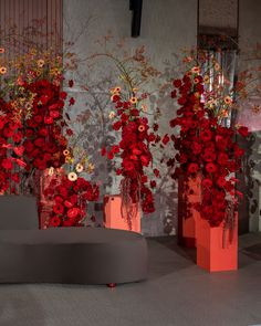 three vases with red flowers are on display