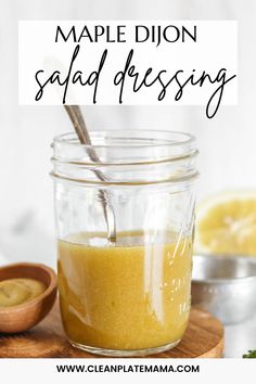 a mason jar filled with homemade dijond salad dressing on top of a wooden cutting board