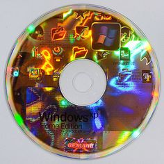 a cd that is sitting on top of a white surface with colorful images all over it