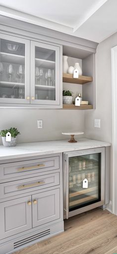 a kitchen with gray cabinets and white counter tops